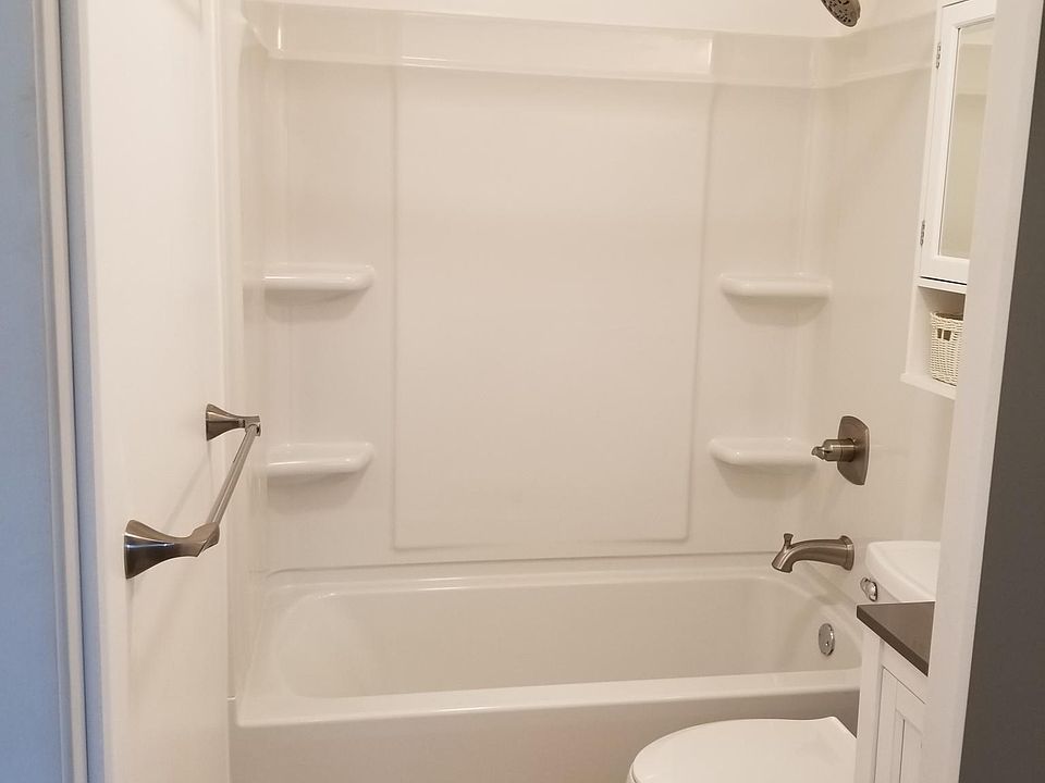 Remodeled bathroom with rainshower shower head. Hotel style bowed shower curtain rod for extra shower space