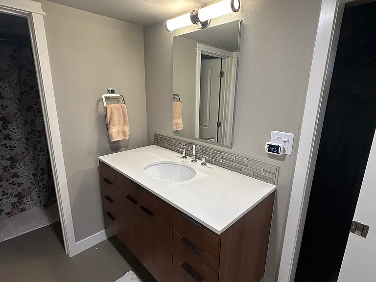 Vanity with mirrored medicine cabinet.
Through the sliding door is the washer and dryer.