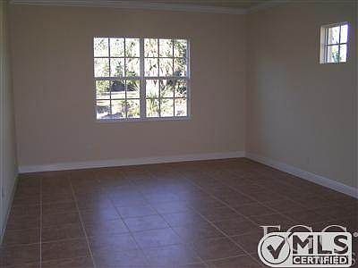 Large living room with tile floors. View to courtyard.