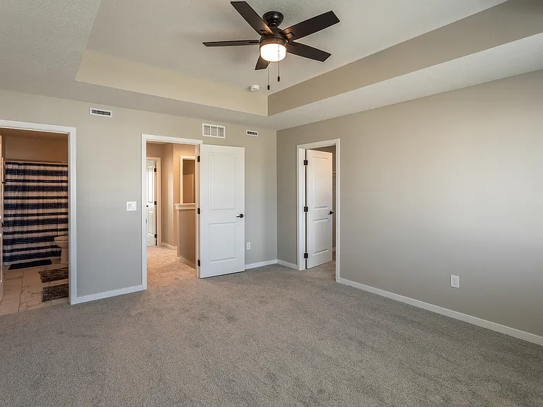 Primary bedroom with tray ceiling. Furniture for staging purposes only, not included.