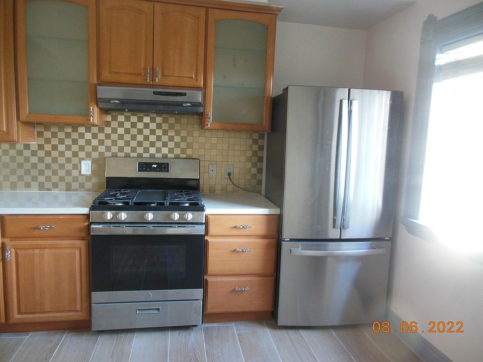 Kitchen with gas stove and large refrigerator.