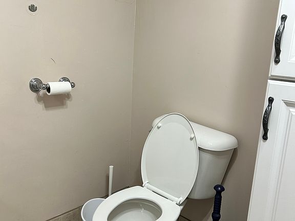 Toilet: linen cabinet on right