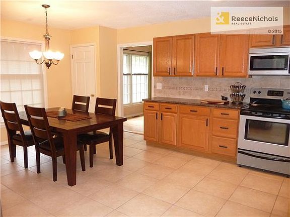 Huge renovated kitchen boasts stainless appliances, dining area, tile floor, newer cabinets and counters.