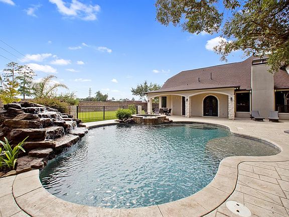 Sparkling Pebble Tec pool, waterfalls, hot tub, tanning shelf, and sprayers.