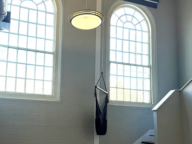 Living room with Brownolow's original 12 ft tall gymnasium windows