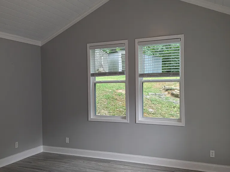 Master bedroom with ceiling fan. View into backyard