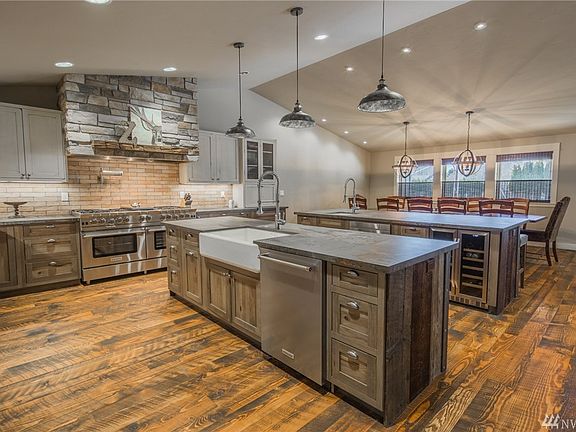 Both islands are custom wrapped in repurposed barn wood from an old chicken coop that was on this property. West Ninth Village farmhouse pendants. Second island seats 5, and has an under counter microwave, wine fridge, Kohler prep sink, & a garbage cab.