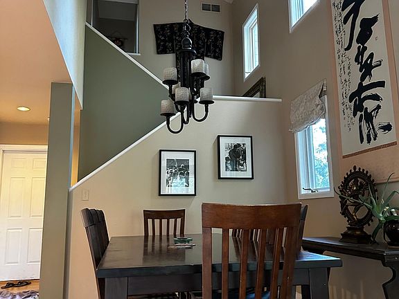 Dining area with vaulted ceilings and stairs to second floor
