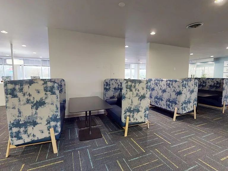 Modern seating area featuring stylish patterned booths and sleek tables, perfect for relaxation or casual meetings in a vibrant atmosphere.