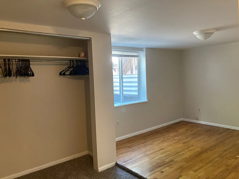 This basement bedroom has both a carpeted area and a slightly raised hardwood area. All basement bedrooms have egress windows, letting in plenty of light.