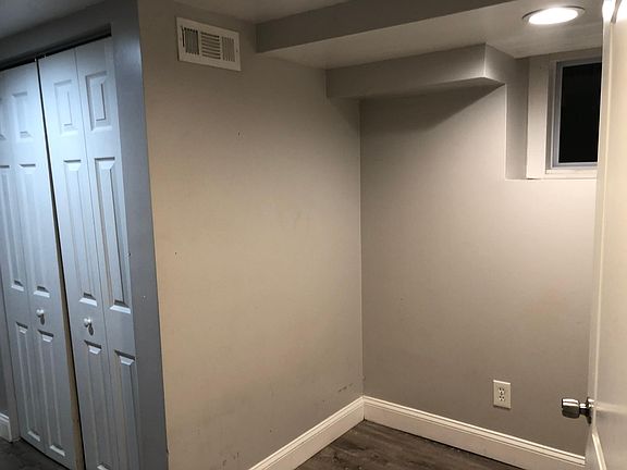 Another photo of small bedroom in basement which has window