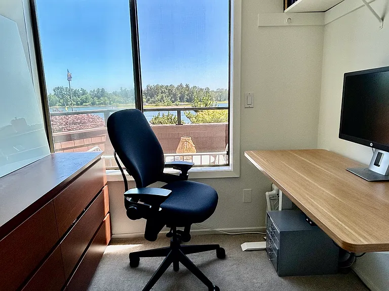 Office off main suite with sit/stand desk, monitor, task chair and glass whiteboard