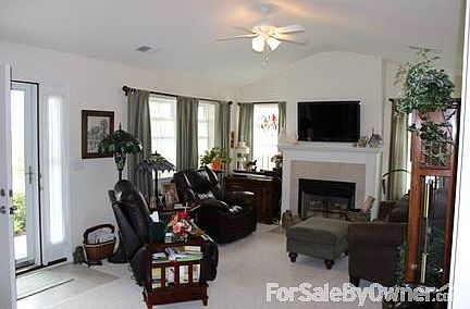 Spacious Living room with wood burning fireplace and cathedral ceiling.