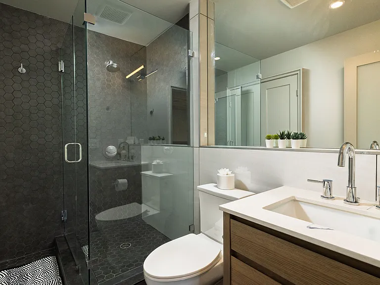 Bathroom 2 has a walk in shower and a cabinet sink with mirror.