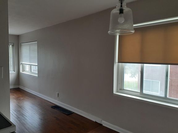 Kitchen window in the foreground and living room windows at the far end