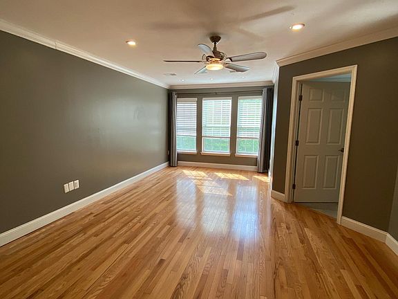 Master bedroom, faces the rear of the house and backyard, with scenic landscaping behind the home. Bedroom lights are on a dimming switch, and the ceiling fan and light are controlled by a remote.