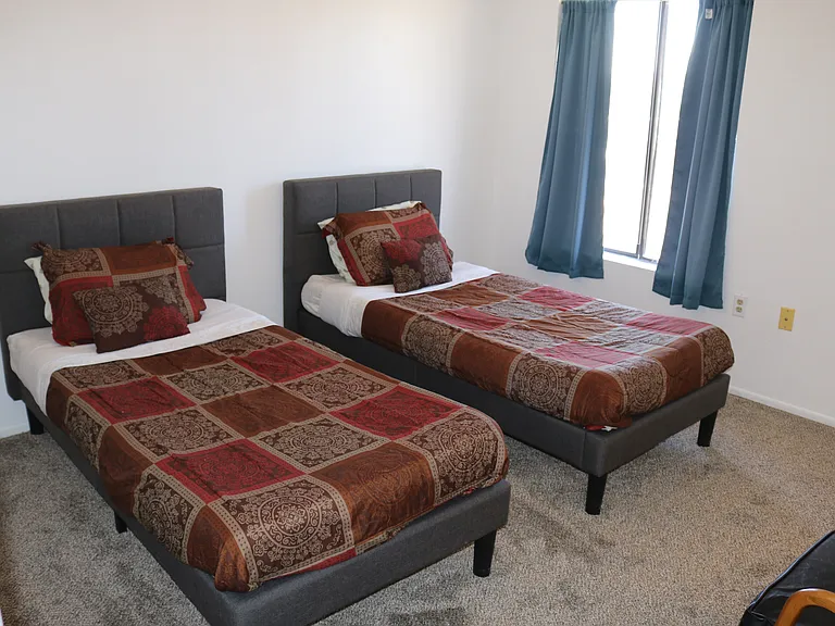 Second bedroom with two single beds. If you are a sole renter, we can remove a bed and add a desk and chair. Contact manager for room changes.