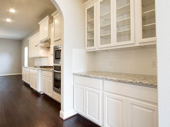 Off the kitchen you will find a butler s pantry with glass panel cabinets.