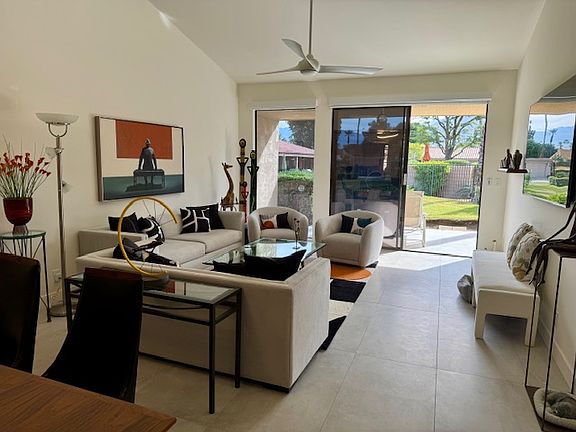 Living room area leading out to back patio, pool/spa and mountain view.
