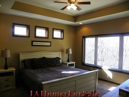 Master Bedroom with tray ceiling and large windows with wooded view