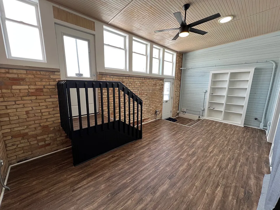 Living room. Patio stairs to the left; front door to the right. Built-in bookcase