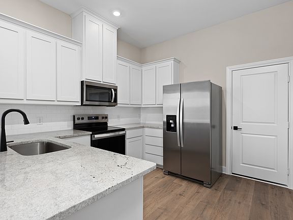 The kitchen has beautiful white wood cabinetry.