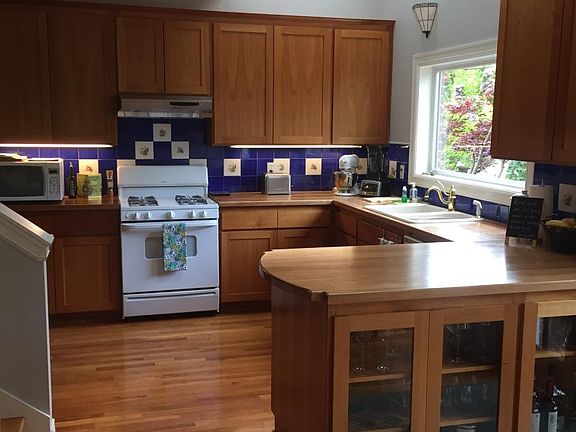 Large kitchen with cherry wood cabinets, counters, floors an