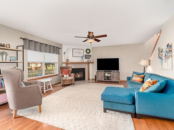 Hardwood floors, ceiling fan, shiplap surround gas fireplace