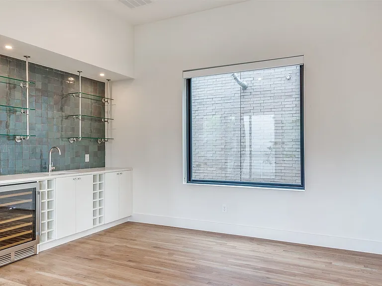 Dining room features a wet bar with glass shelving, plenty of storage cabinets and beverage refridgerator