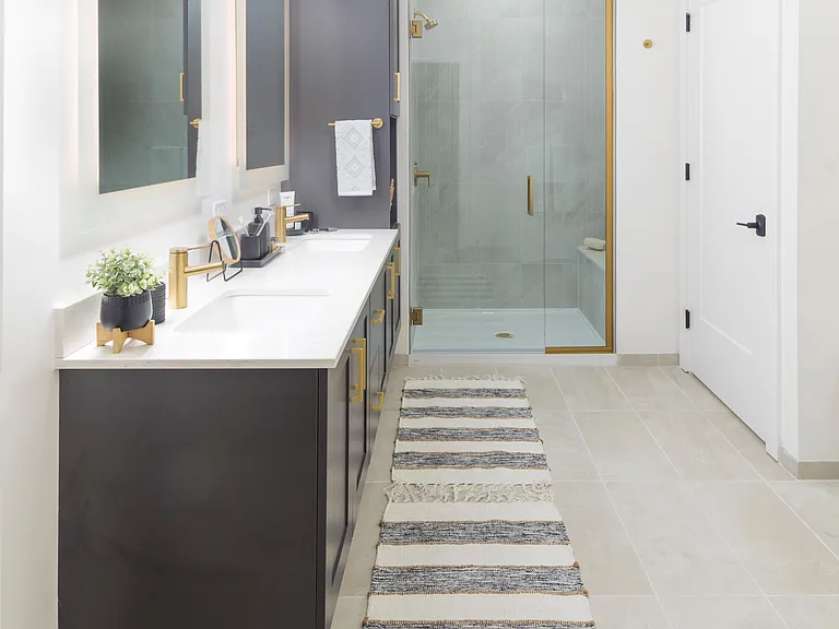 Spa-inspired bathrooms with frameless glass showers and rainfall shower heads, dual floating vanities, backlit mirrors*