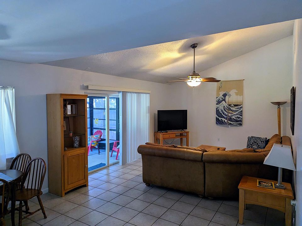 Living room with dining area to left and view to back lanai. Large sectional and recliner plus Roku TV with lots of channels and streaming choices.