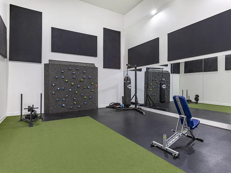 Experience our state-of-the-art gym featuring a dynamic climbing wall and exercise equipment