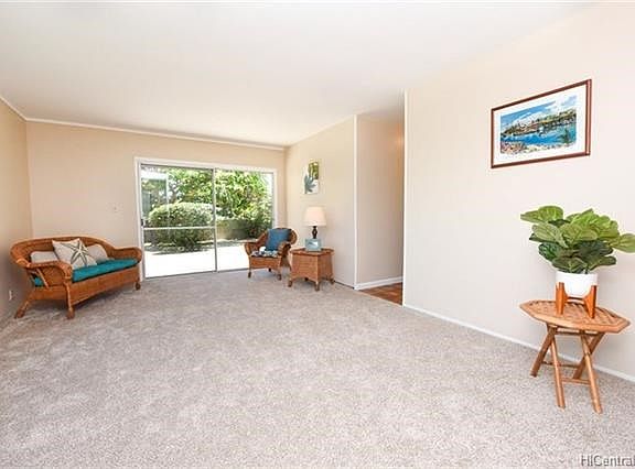 Newly carpeted and painted formal living room with sliding doors to the grassy back yard