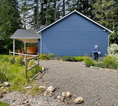 Side of house with rain garden to left and garage to the right.