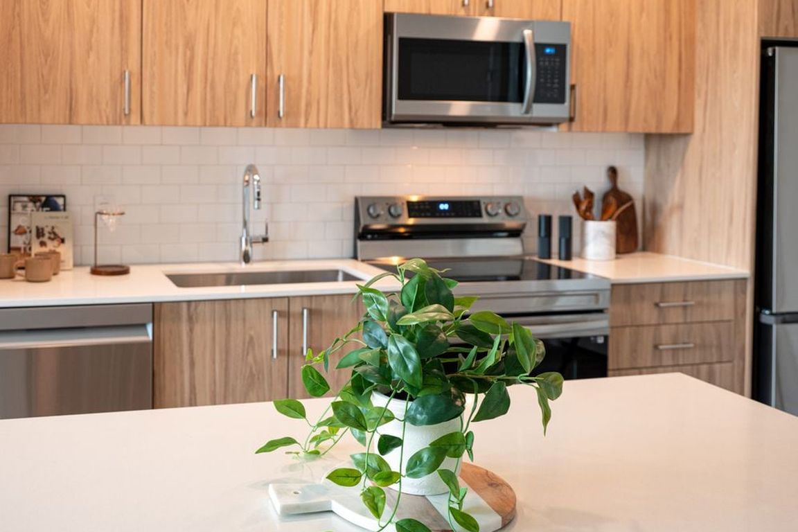 Kitchen with oak cabinetry, stainless-steel appliances, hard-surface flooring and granite countertops