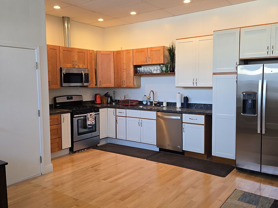 Near front door looking at kitchen. New refrigerator, new countertop, all pull out drawers in base cabinets