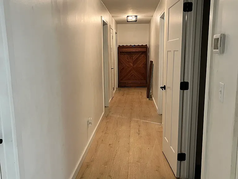 Hallway that leads to three bedrooms and three bathrooms