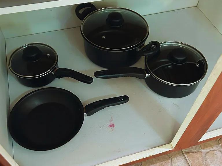 Well-equipped kitchen with pots, pans, and lids for home-cooked meals.