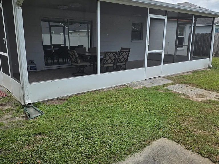 backyard picture showing screened in patio