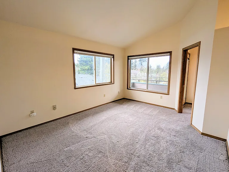 209 Living room with vaulted ceilings and access to 2nd bedroom/office and balcony