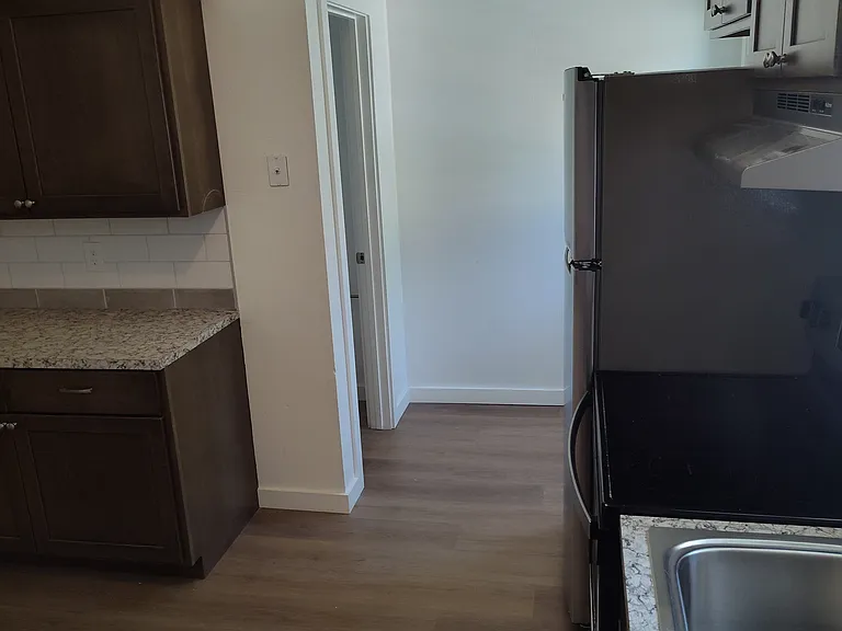 Kitchen standing by the dishwasher looking at the 1/2 bathroom door.