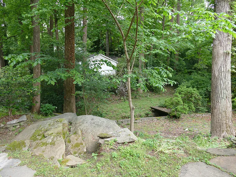 Large side yard with quiet creek, good for parties.