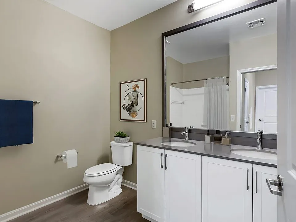 Renovated Package II bath with grey quartz countertops, white cabinetry, and hard surface flooring