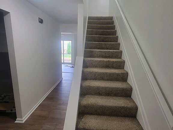 At the entry: Stairs go up to bedrooms, Living room is to the left, Family room is straight ahead down the hall.