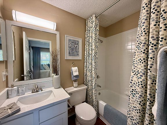 Bright bathroom with granite counters and bathtub
