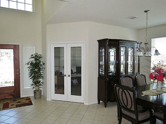 Adjacent to the entry way is an office nestled behind glass doors and overlooking the front yard.