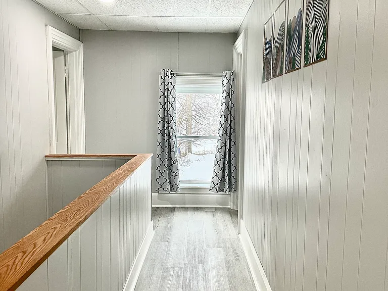 This bright and airy hallway is filled with natural light, with all windows featuring black-out shades for added comfort and privacy.