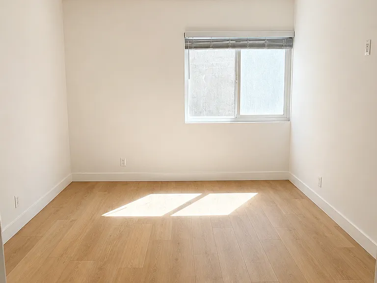 Bright bedroom with ceiling fan, recessed lighting, window coverings, and light wood-style flooring.