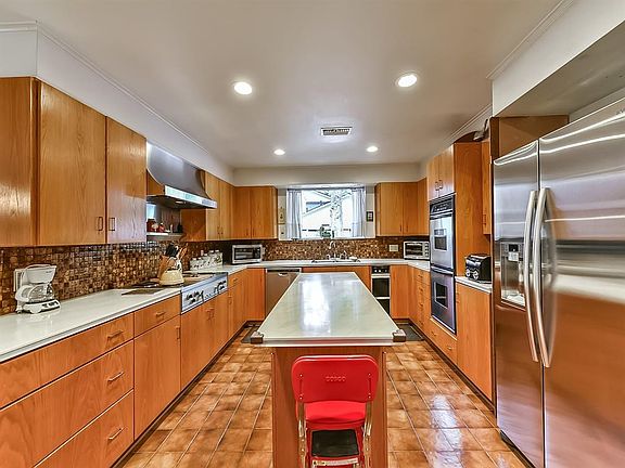 Spacious island kitchen offers double oven and picture window viewing the backyard and pool.