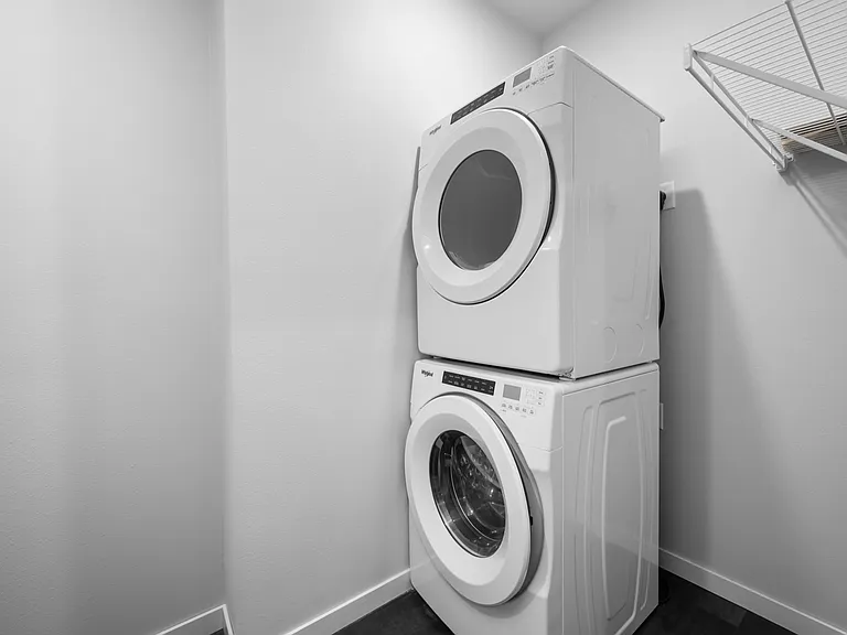 Modern laundry room with stacked washer and dryer, offering efficient and sleek design. Modern laundry room with stacked washer and dryer, offering efficient and sleek design.